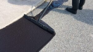 Sealer is hand squeegeed around curbs